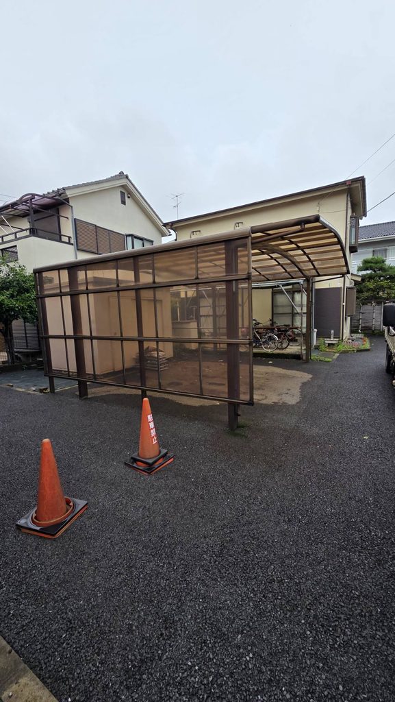 相模原市相模大野の交換前のカーポート。ブラウン系のフレームと側面パネルがある駐車スペース